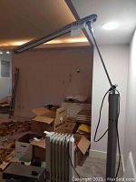 Complete side view of the standing lamp showing full height, horizontal arm, and base with surrounding environment.