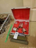 Open box showing three silver-plated mesh canisters and two lids in red satin-lined silver-finish box