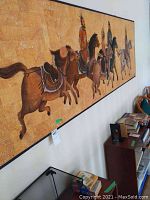 Left angled view of horizontal cork painting showing six mounted horsemen with earth tone backgrounds in wood frame.