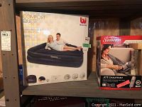 Photo showing Comfort Quest Bestway air bed box and Sunbeam heated throw box on shelf.