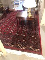 Partial full view of rug under coffee table and lamp showing overall pattern and color.