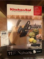Front and top view of the KitchenAid 11 piece forged cutlery set new in packaging with photo of wood block holding knives and scissors.