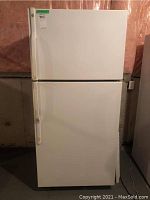 Front exterior view of white GE TBX19ZA refrigerator with separate freezer compartment, doors closed.
