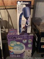 Photo showing boxed Pollenex Pressure Response Massager and boxed Conair Foot Spa together, providing overview of lot items and their packaging.