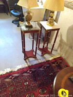 Image showing the two wooden plant stands side by side with table lamps on top and a carpet underneath.