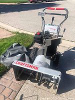 Front view of snowblower showing body, engine, handle assembly