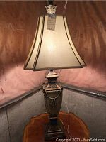 Full view of the table lamp showcasing the ornate base and fabric shade.