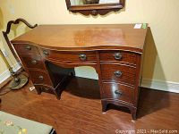 Full view of wooden dresser showing shape, drawer arrangement, and overall condition.