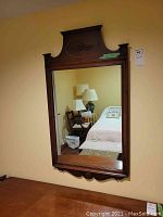 Full view of the rectangular mirror showing the wood frame and reflection of room.