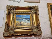 Framed seascape painting signed 'Nand' showing children on the beach with sailboats in the background
