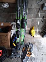 O'Brien P173 water skis leaning against a wall with K2 Rollerblades, Power Ridge snowshoes, and lifejacket in front.