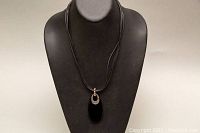 Full view of the necklace showing the length, pendant, and multiple leather strands.