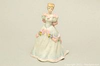 Front view of Coalport Beau Monde Deborah porcelain figurine showing pastel gown with ruffles and floral accents.