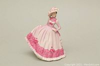 Front view of Coalport Beau Monde Jill porcelain figurine showing detailed pink and white dress and bonnet.