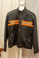 Front view of Harley Davidson leather biker jacket showing orange stripes and zippered pockets.