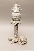 Full view of the incense burner showing pagoda-style top and rounded perforated body with Asian symbol.