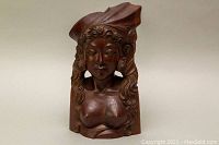 Front view of vintage solid rosewood carved tribal woman sculpture showing detailed face, curly hair, and part of the headdress.