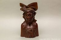 Front view of the carved rosewood tribal bust sculpture showing facial features and headdress detail.