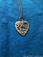 Close-up of the heart-shaped pendant with 'I Love You' scripted cut-out design in 10KT gold