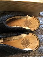 Close-up of the insoles showing UGG logo and soft wool lining inside the clogs.