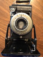 Close-up front view of camera lens with aperture and focus markings, showing the Kodak No.1 Diomatic inscription.