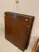 Back side of one wooden wall art panel showing distressed wood and notched edges.