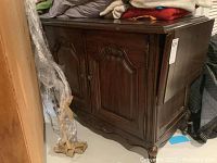 Full view of wooden buffet showing drop leaves, carved details, dark finish, casters visible under base.