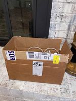 Wide shot of cardboard box containing Google Home devices and cords