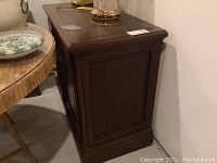 Side view of the wood sideboard showing paneling and finish detail.