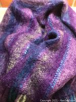 Close up showing soft, fuzzy texture and striped pattern in rich eggplant purple with accents of turquoise and pale green.