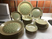 Full set arranged on countertop showing all dinner plates, luncheon plates, dessert plates, cereal bowls and saucers