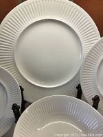 Front view of single dinner plate on easel showing ridged rim design