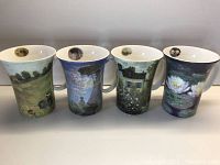 Four ceramic mugs in a row showing Monet paintings including garden, house, and water lilies
