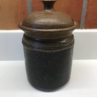 Full view of the ceramic jar with fitted slotted lid, showing the cinnamon and chocolate glaze with speckling.