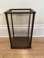 Full view of the display case showing the wood frame and clear plexiglass panels.