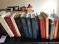 Books mostly religious, showing titles such as 'The Strong's Concordance of the Bible', 'Mysteries of the Bible', 'God's Plan for Man', two 'The Hymnal' editions, 'Ideal Dictionary', and other devotional books on a shelf.