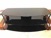 Front view of the entertainment stand showing three black glass shelves with curved wooden sides.