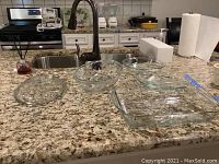 All five glass baking dishes displayed on kitchen countertop including pie pans, casserole dish, covered oval dish, and additional baking dish.