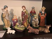 Front view of nativity scene with all 10 bisque porcelain figurines displayed including human characters and animals.