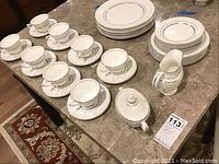 Full set laid out on table showing 8 teacups with saucers, 8 bread plates, 8 salad plates, creamer, and covered sugar bowl.