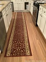 Kitchen featuring the long runner rug laid along the floor between cabinets and appliances, showing overall size and placement.