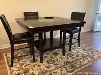 Wide shot showing full square table with lazy Susan and four chairs
