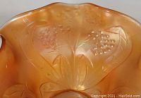 Close-up of embossed Flowering Dill floral pattern on marigold carnival glass showing flower clusters and leaves with iridescence.