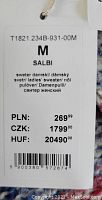 Close-up of the price tag showing size Medium, item code T1821.234B-931-00M, and multi-language labeling indicating it is a ladies sweater/pullover made in Poland.