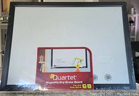 Front view of the white dry-erase board with black frame, showing original Quartet packaging.