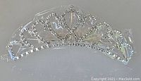 Front view of the sparkling small tiara attached to the comb, showing rhinestone design and shape.