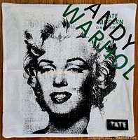 Front view of square cushion with black and white Marilyn Monroe print and green/black text "ANDY WARHOL" with Tate Modern exhibition dates.
