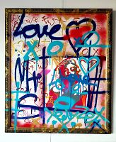 Frontal view of signed multicolor graffiti painting in vintage gold wood frame on white wall