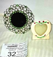 Bejeweled round silver-tone frame with green rhinestones and hand painted white ceramic heart frame with floral design
