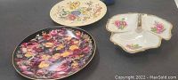 Photo showing two floral collectible plates and three-part floral relish dish with handles